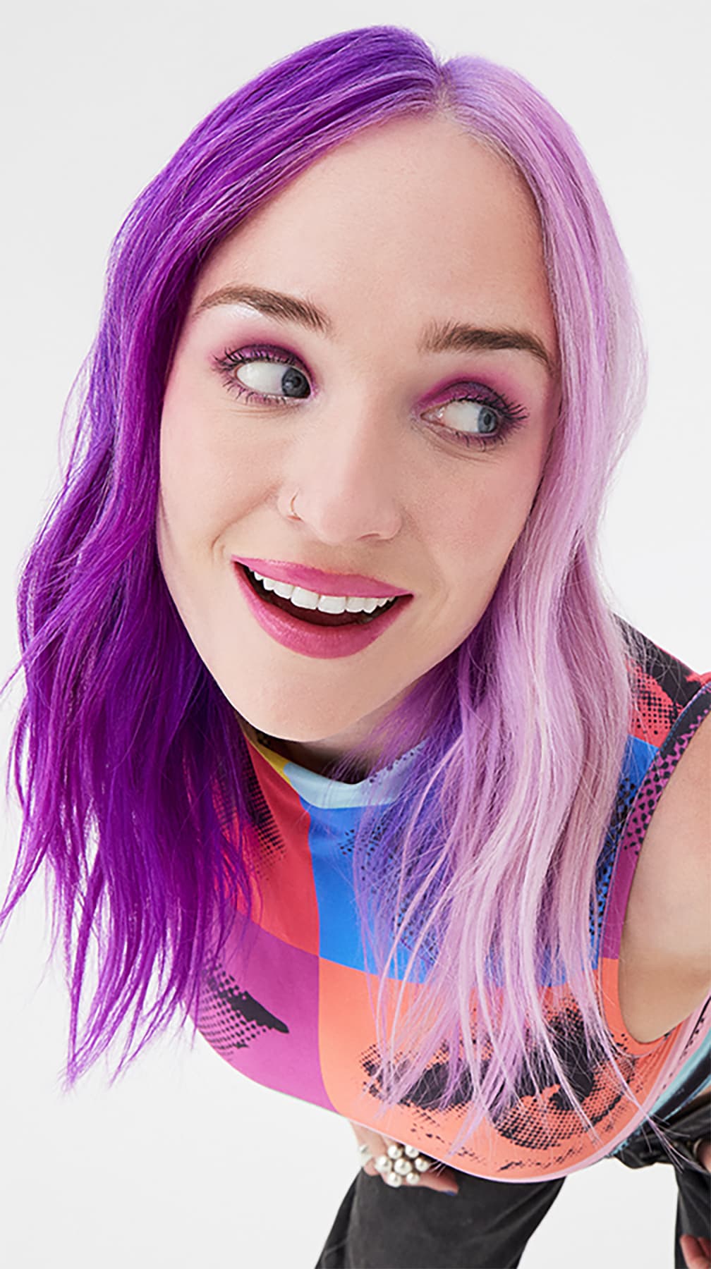 Enthusiastic woman with a bright smile, showcasing Arctic Fox's Purple AF and Girls Night hair colors, creating a stunning ombre effect from deep purple to soft lavender.